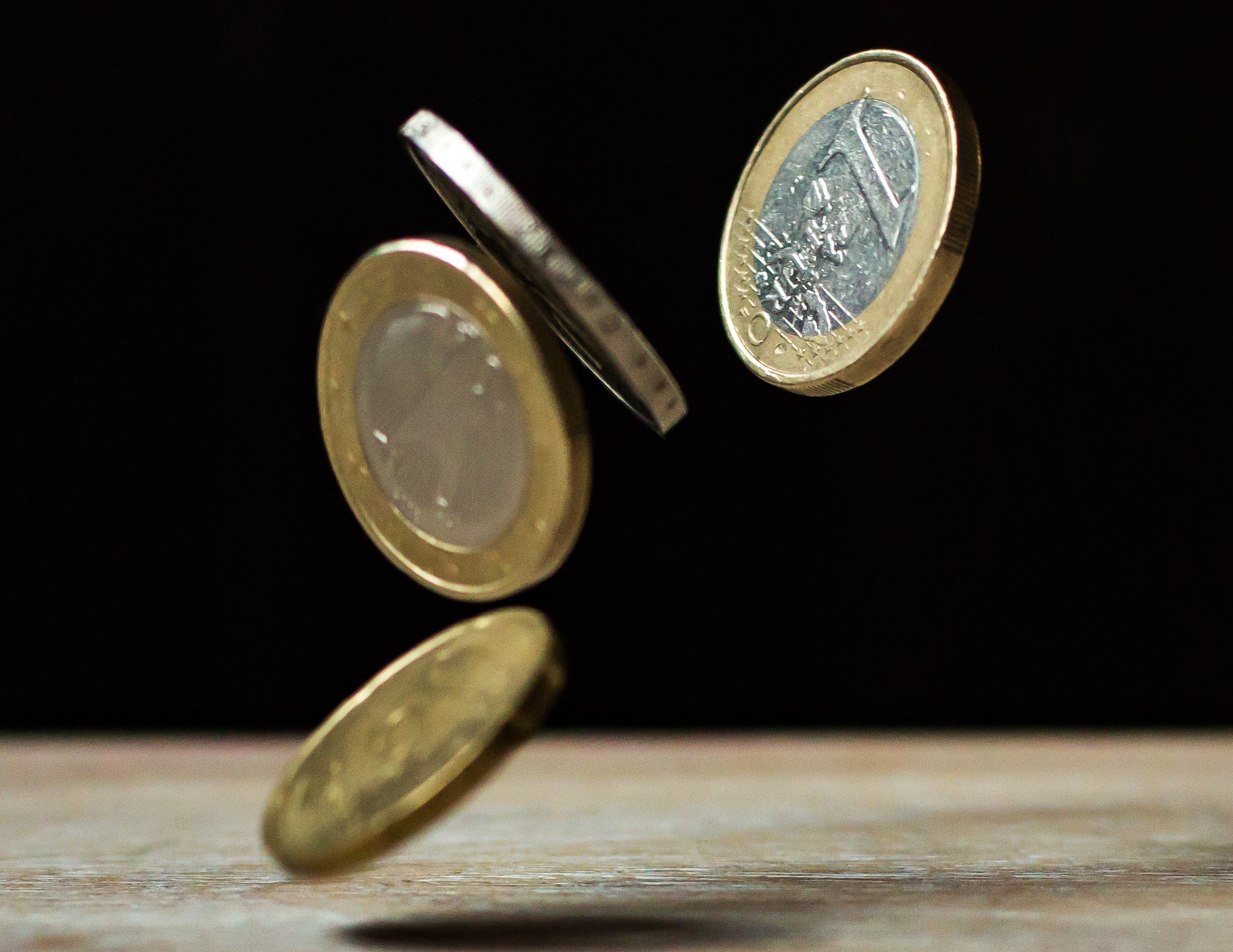 Euro coins bouncing off a table
