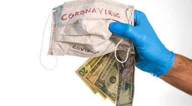 Hand,With,Dollar,Bills,And,A,Face,Mask,With,The