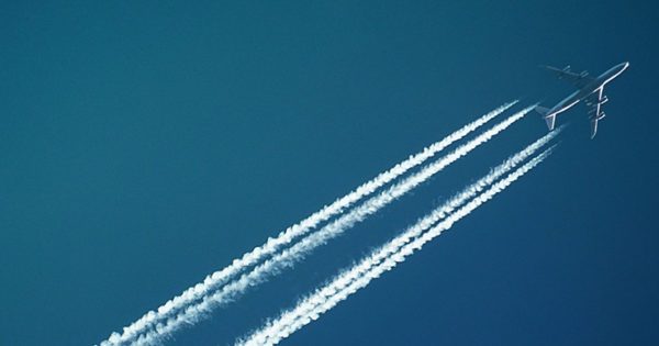 airplane_crop A plane cuts diagonally across a deep blue sky, leaving contrails behind it
