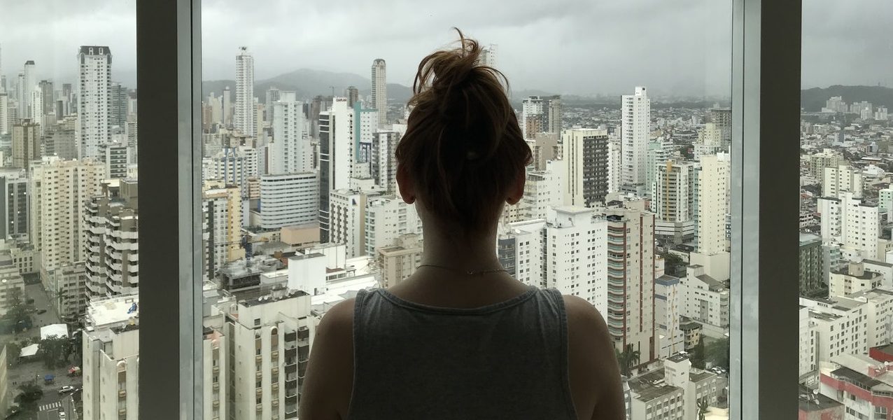 Woman looking at city outside window Woman looking at city outside window