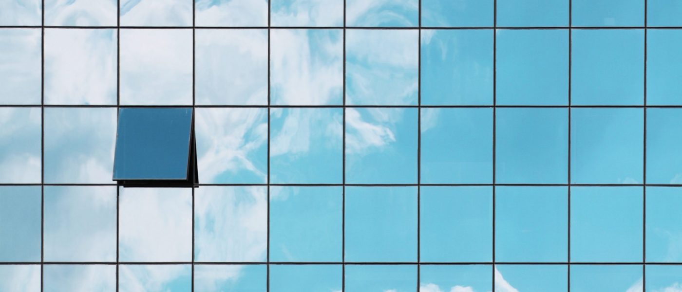 open window glass skyscraper blue sky A single open window in a grid of closed glass windows mirroring the sky